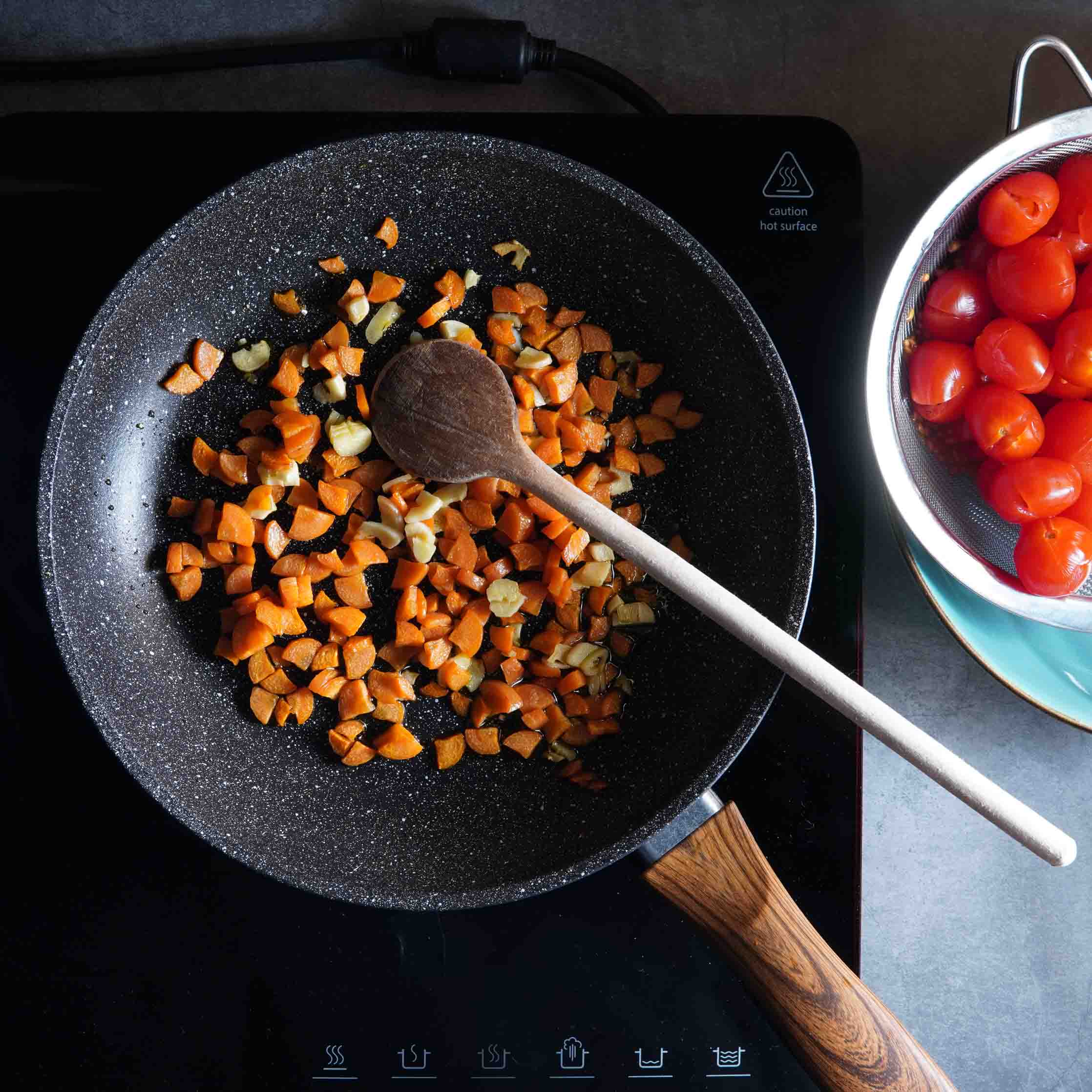 Spaghetti Pomodoro vegan. Schritt 2. Zwiebeln und Karotten in einer Pfanne anbraten.