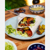 Wraps vegan auf einem Teller angerichtet, darum Dips wie Guacamole und Relish gestellt, Hero